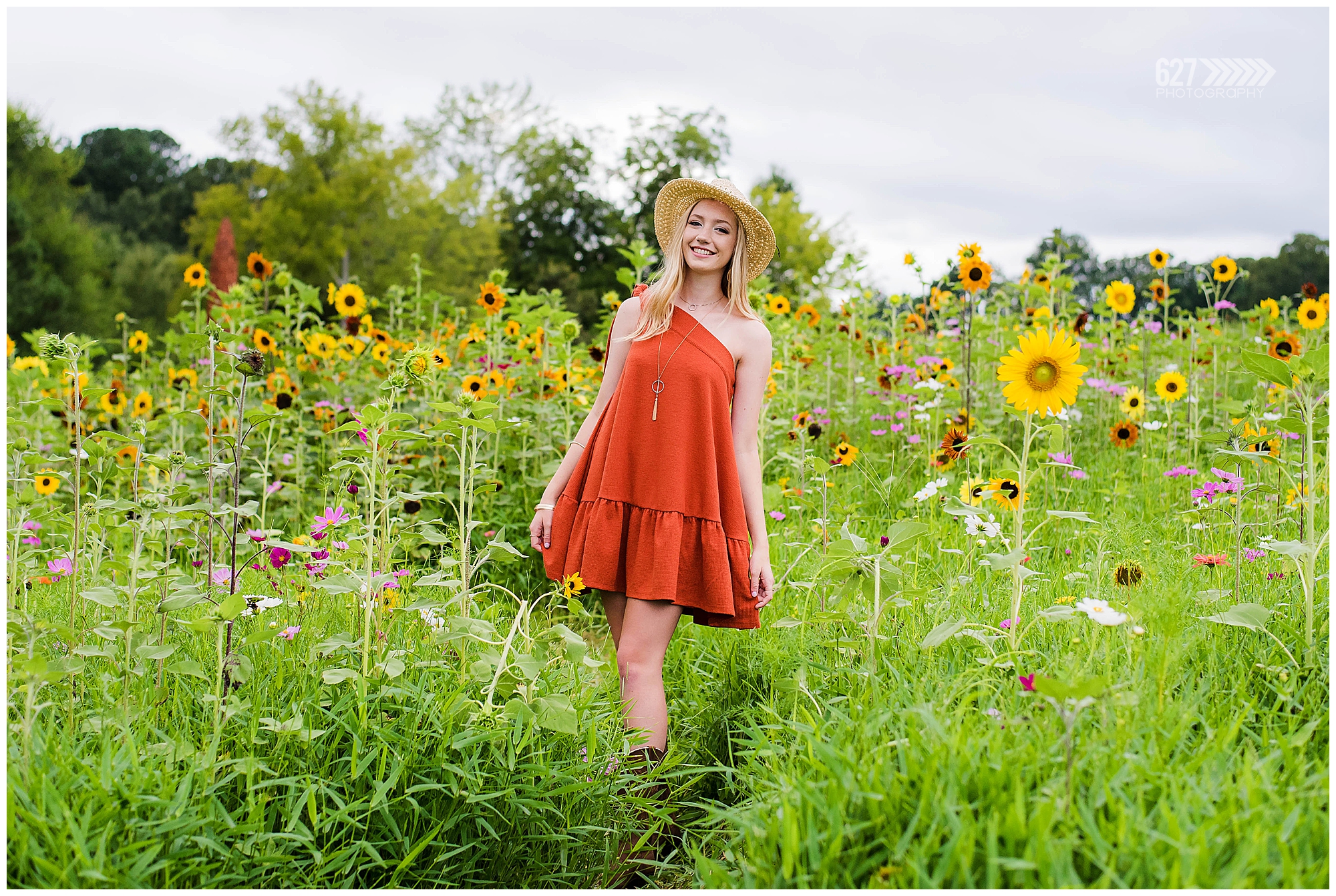 senior girl in flower field with straw hat