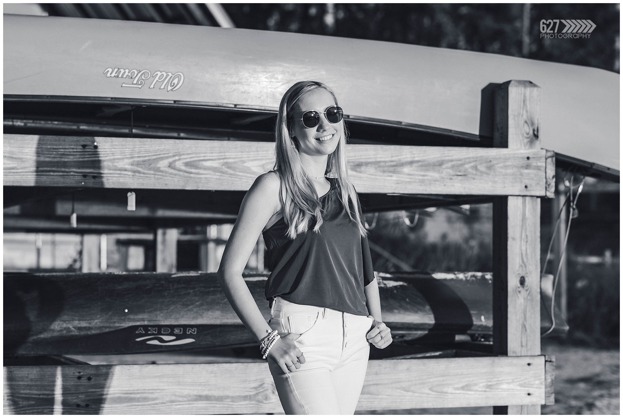 senior girl by the lake canoes black and white sunglasses