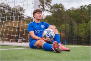 Senior photos of high school guy on soccer field in Apex North Carolina