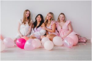 Senior model team girls in pink and white outfits in a bright studio in Raleigh NC