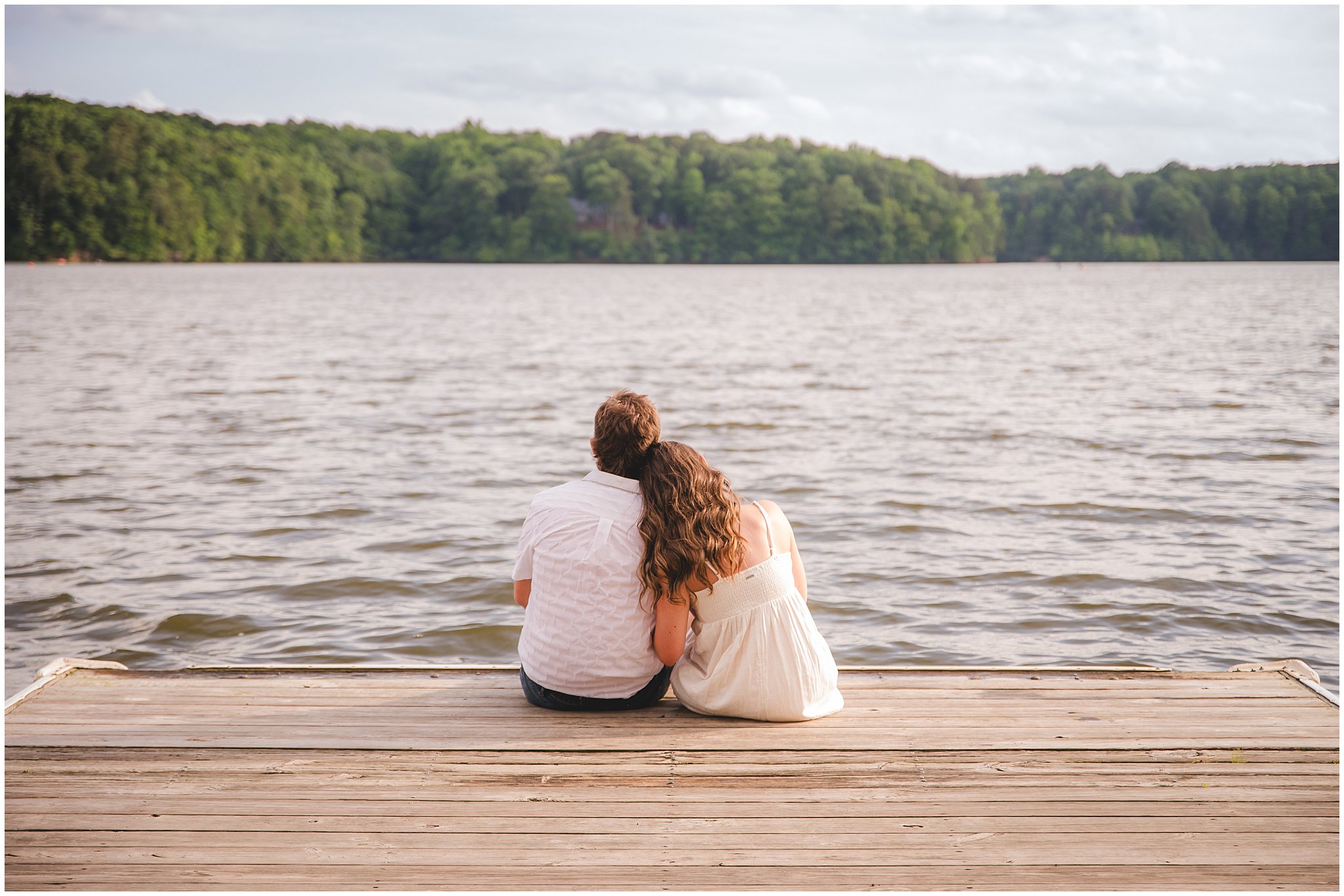 Couple portrait of Emilee and Wesley on the dock at Lake Wheeler